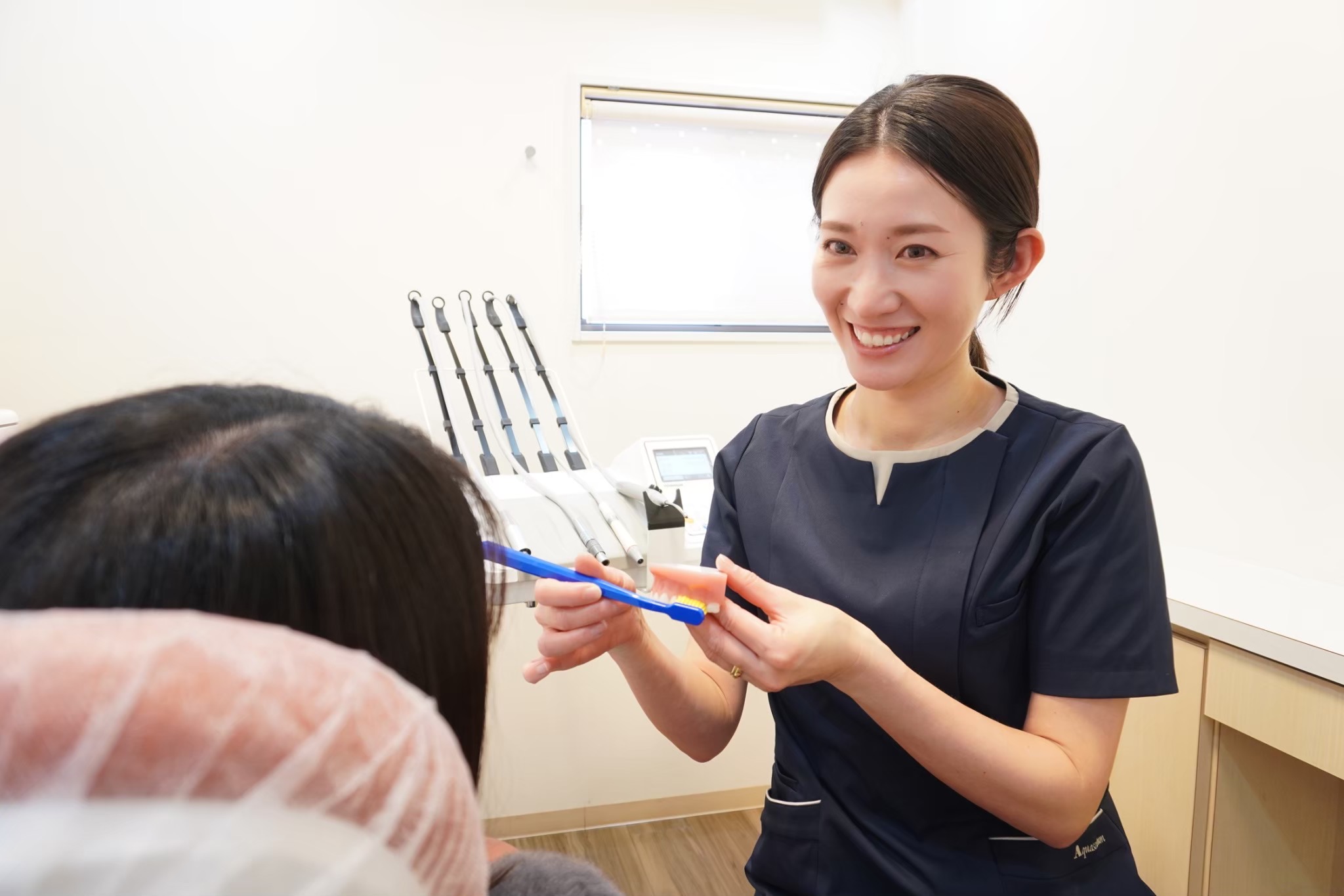 画面を見ながら笑顔で語り合うあかつき台歯科のスタッフ