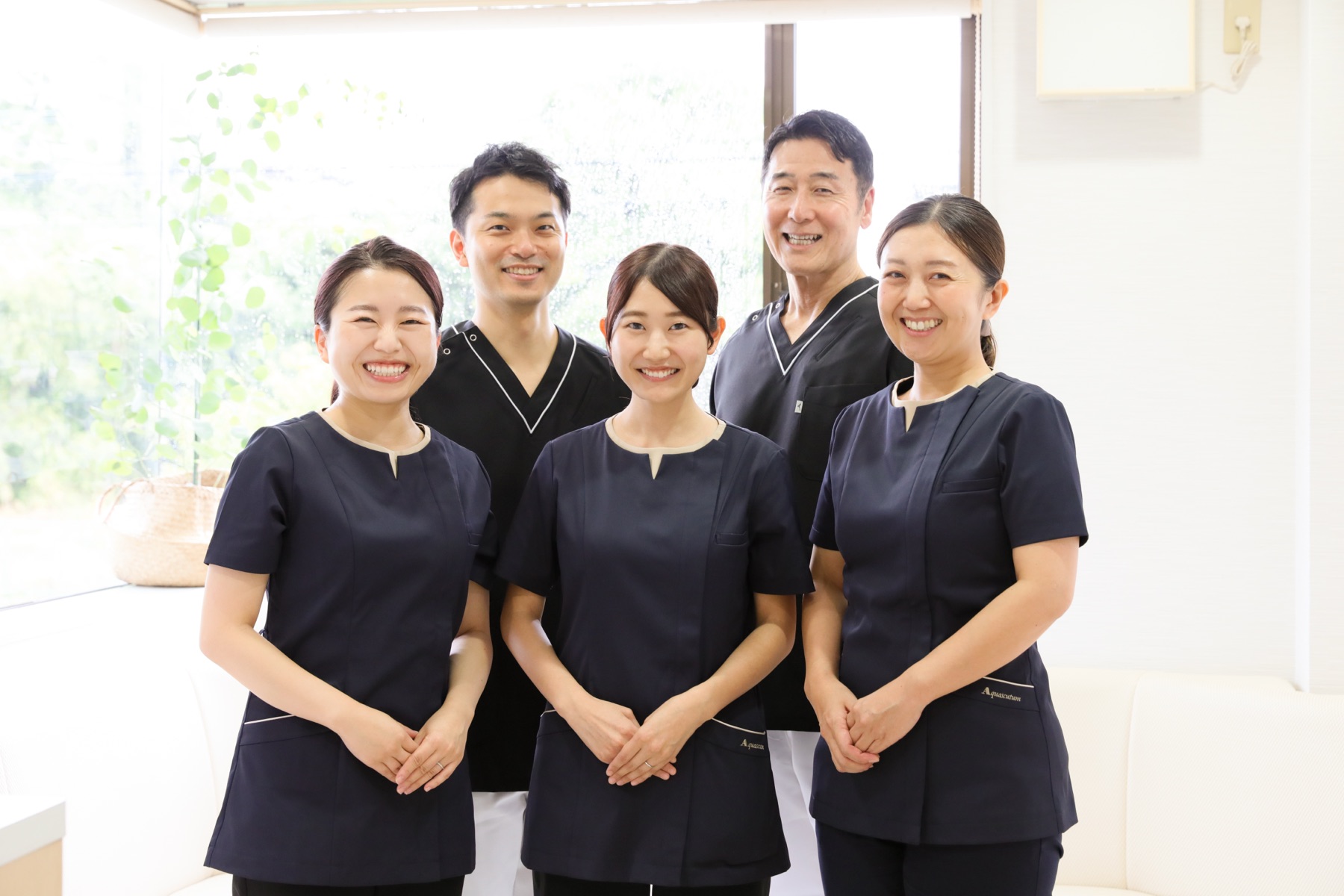 手を重ねるあかつき台歯科医院のスタッフ